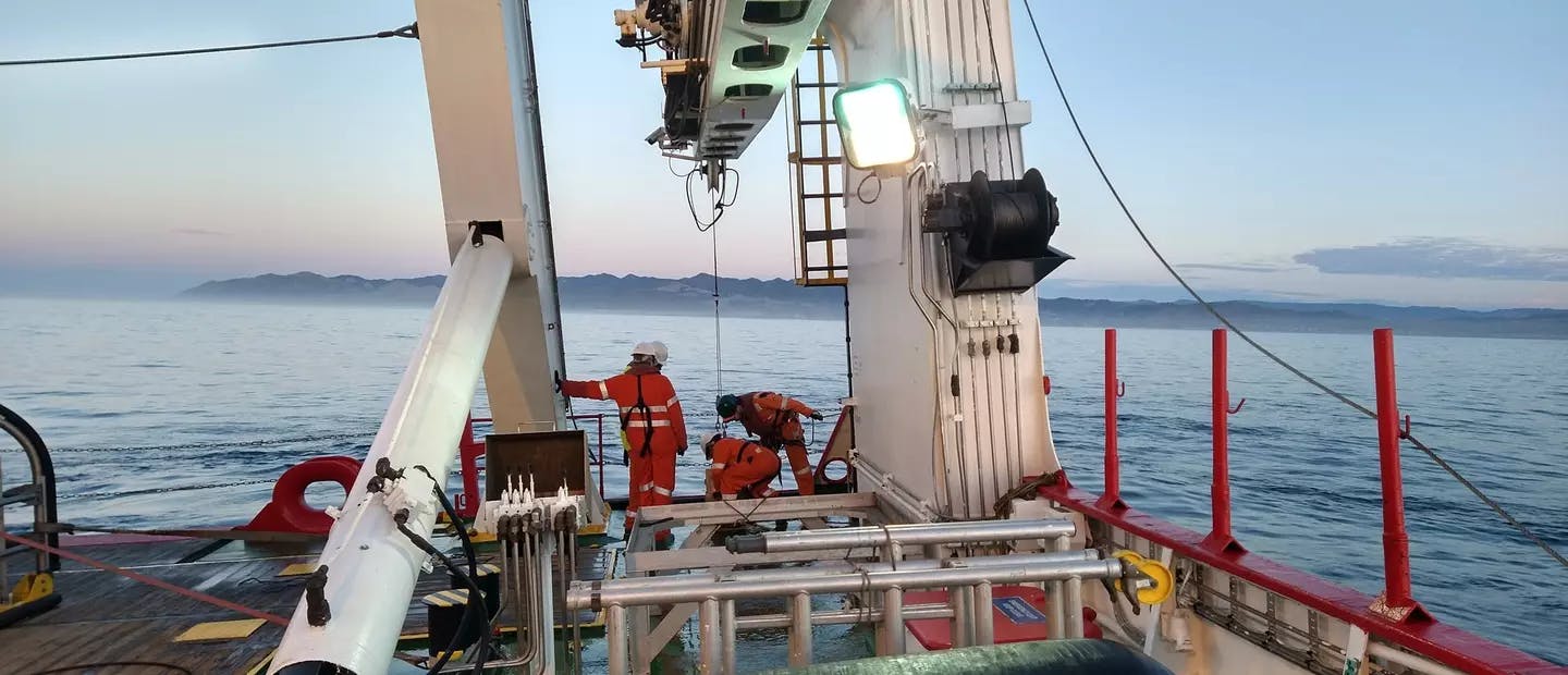 Seabed sampling with van Veen grab off the Fugro Discovery. Geologist is checking the sample quality